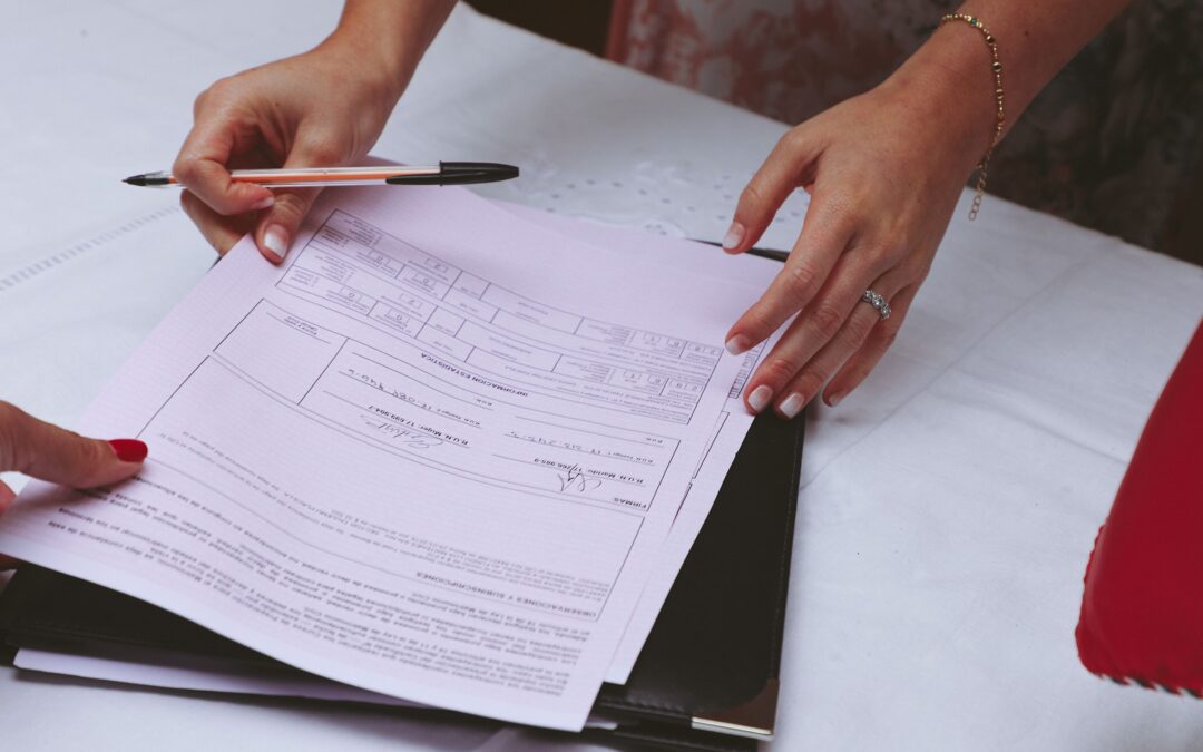 A parent organizing school documents and evaluation reports into a labeled folder on a kitchen table
