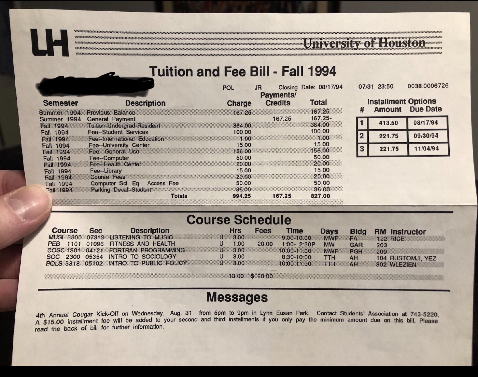 A student holding a tuition bill statement while standing near a campus administrative office window